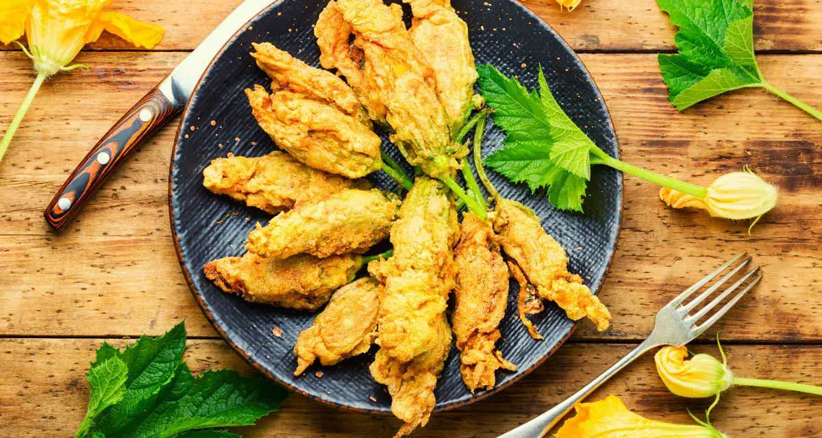 Fiori di zucca in friggitrice ad aria, dorati e croccanti, pronti per essere gustati.