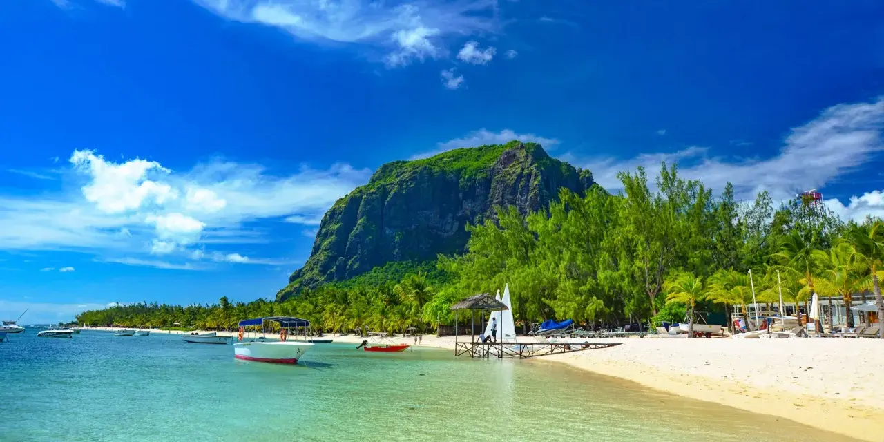 Rajskie plaże Mauritiusa: turkusowa woda, biały piasek, palmy i majestatyczna góra Le Morne Brabant.