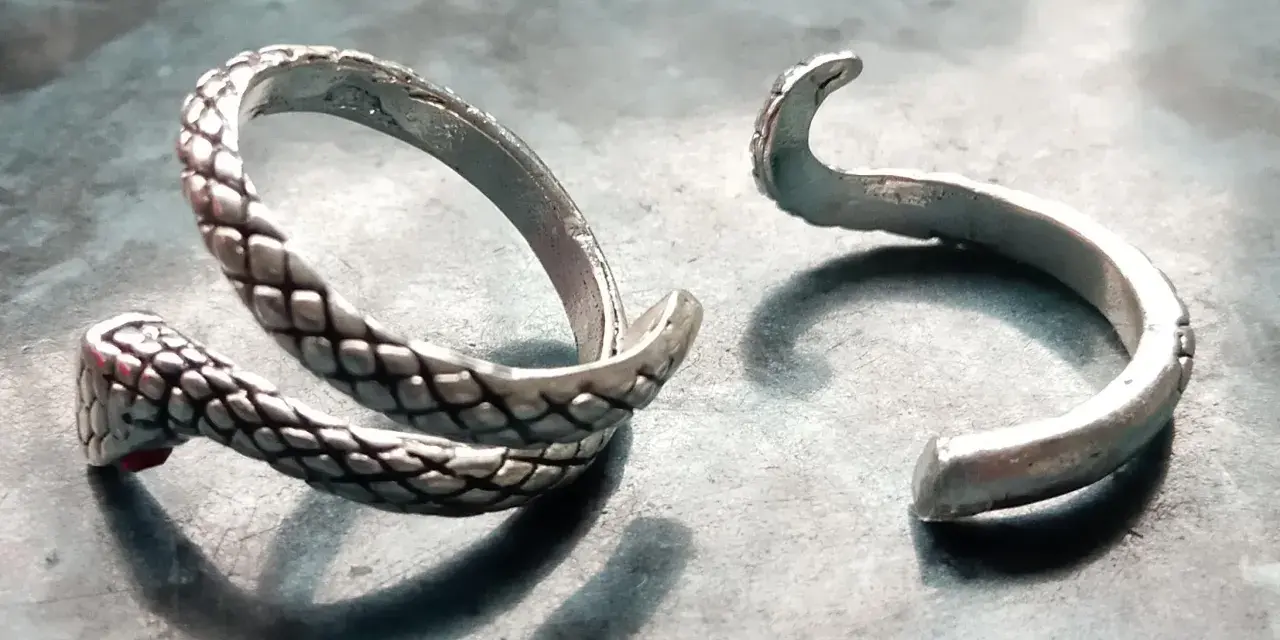 Anello a serpente spezzato, con la testa e il corpo da un lato e l'estremità aperta dall'altro. Un'idea su come aggiustare un anello spezzato.