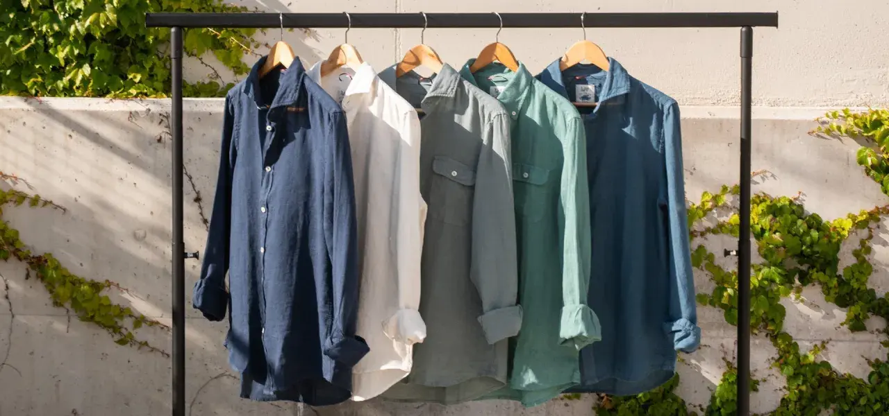 Cinco camisas de lino de colores cuelgan en una percha. El lino, de donde viene el lino, es una fibra natural.