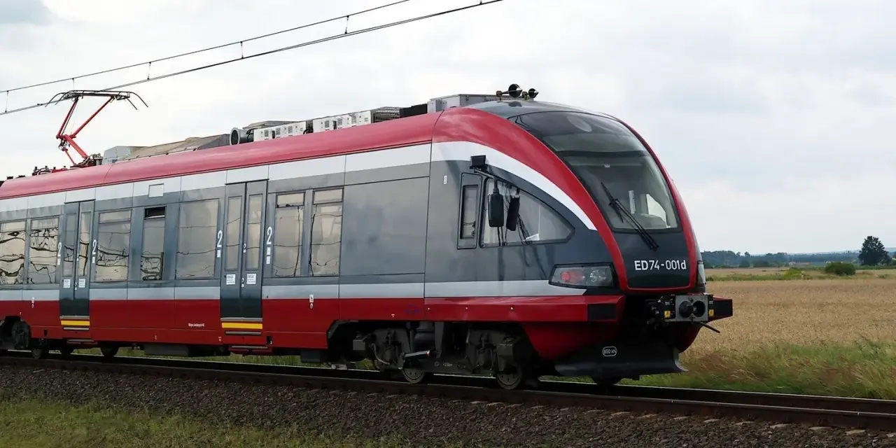Nowoczesny pociąg PKP, idealny do sprawdzenia pkp busko-zdrój rozkład jazdy. Pędzi przez pola.