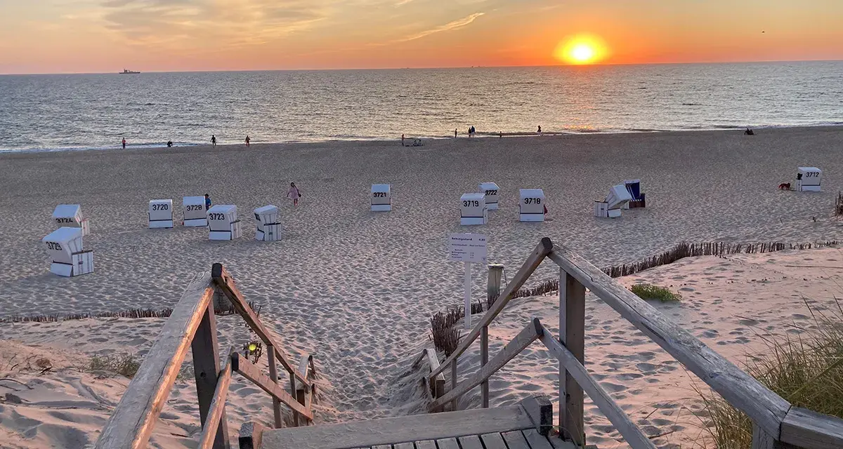 Sonnenuntergang am Strand von Sylt. Strandkörbe warten auf Besucher, die die schönen Ausflugsziele Sylt genießen.