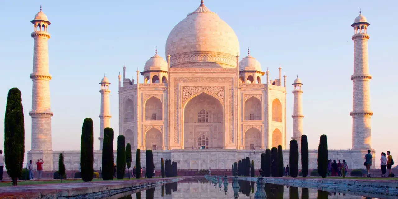 El Taj Mahal, un mausoleo de mármol blanco, se refleja en el agua. Es una maravilla arquitectónica, un símbolo de amor eterno.