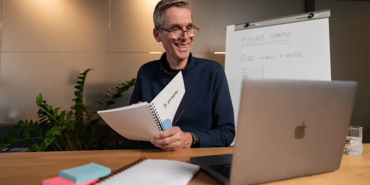 Lehrer erklärt auf Englisch "Future Simple", ein Adjektiv oder Adverb, mit einem Lächeln.