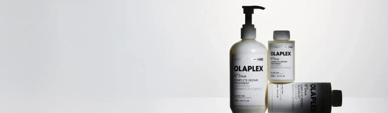 Tres botellas de Olaplex N°3, tratamiento para pelo seco o mojado, en un fondo blanco.