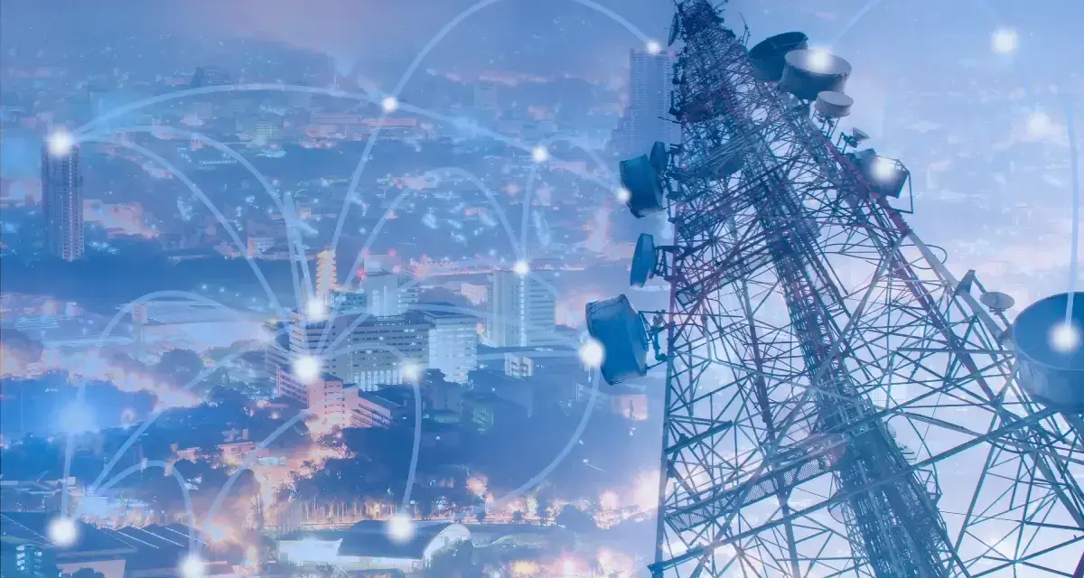 A telecommunications tower overlooks a city, with glowing lines connecting points, symbolizing network planning and optimization.