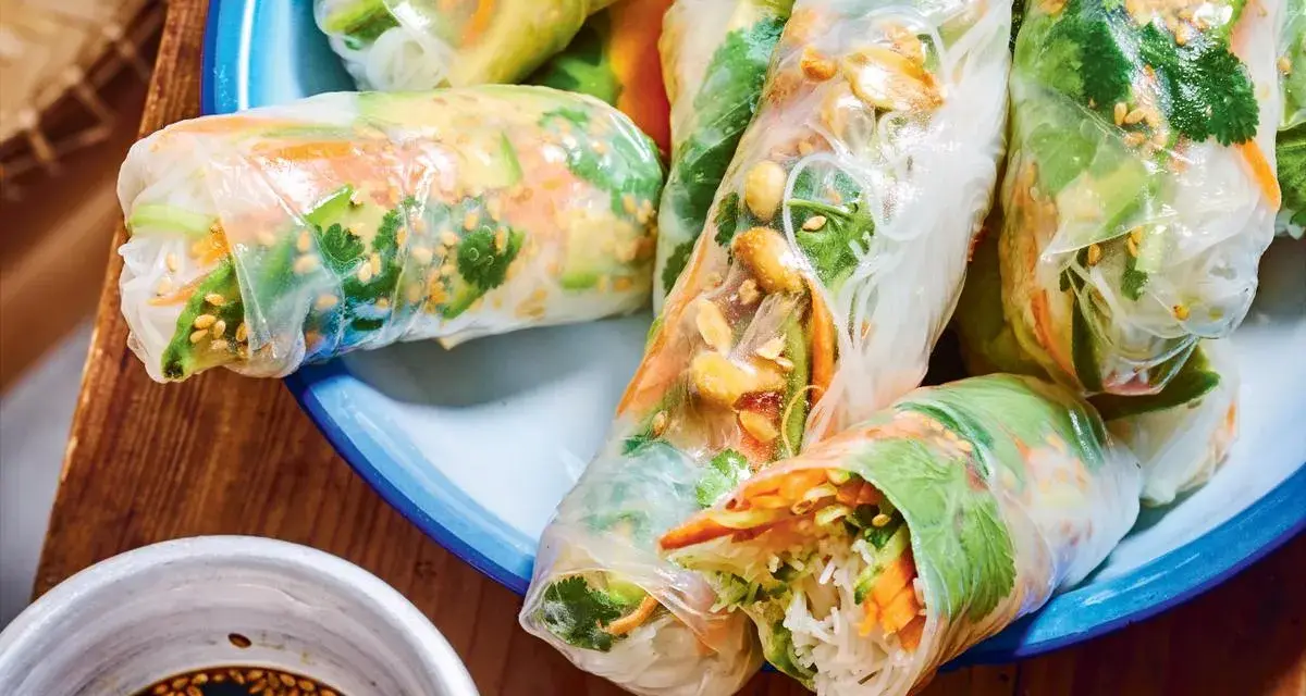 Rouleaux de printemps frais et colorés, parfaits pour une recette facile. On y voit des vermicelles de riz, des légumes croquants et des cacahuètes.
