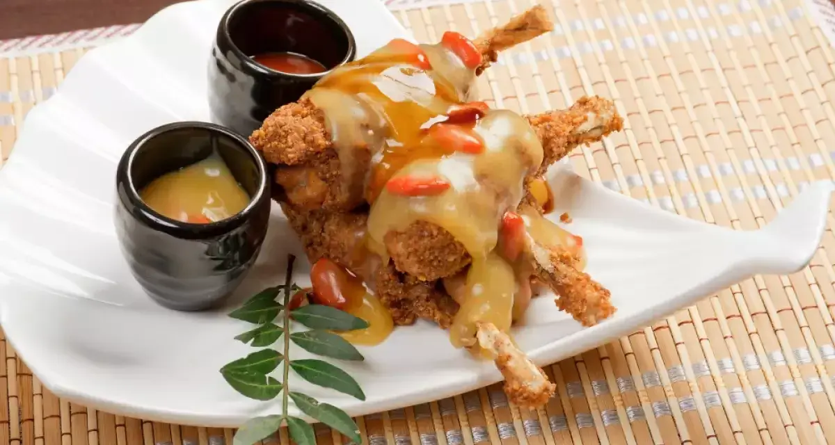 Ancas de rana crujientes con salsa dorada y gominolas rojas, acompañadas de dos salsas. Una deliciosa receta francesa.