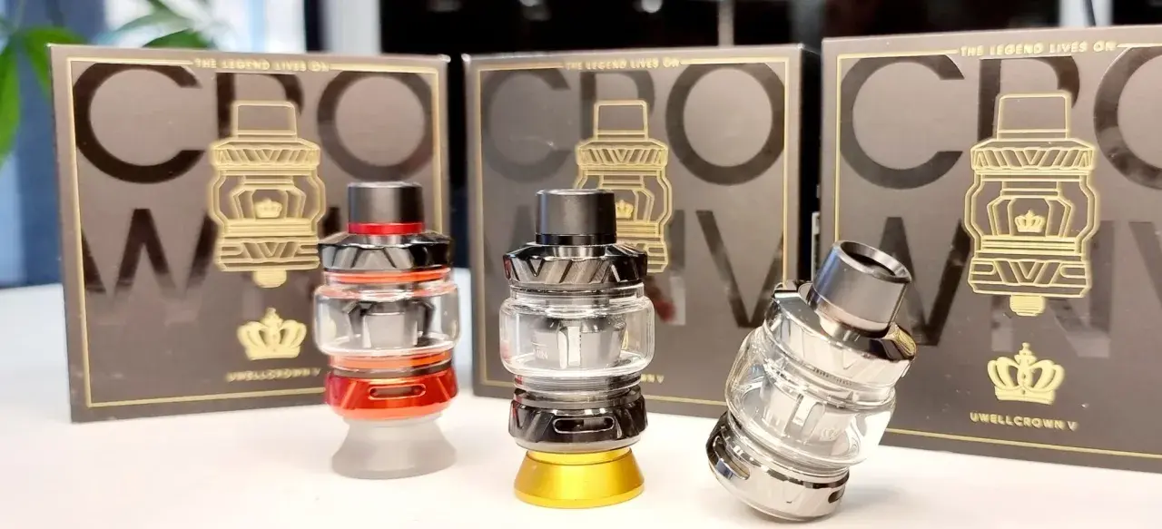 Tres atomizadores Uwell Crown V en rojo, negro y plateado, con sus cajas de fondo.
