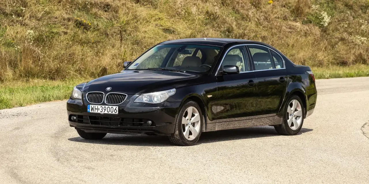 Czarne BMW 535d na tle zielonego wzgórza.