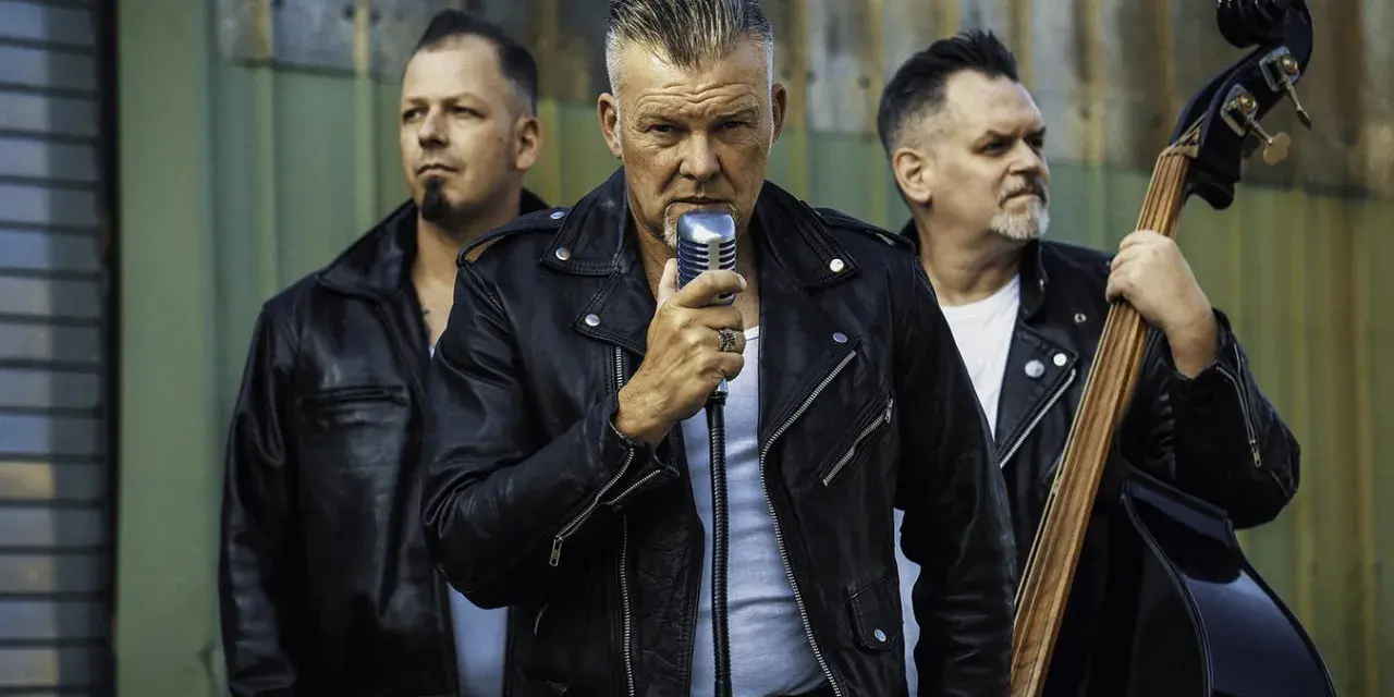 Rock n roll band in Lederjacken. Sänger hält Mikrofon, Bassist spielt Kontrabass, Schlagzeuger hält Sticks.
