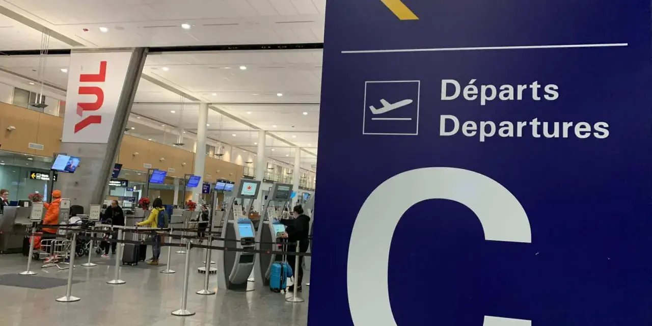 Tablica kierująca na lotnisku Montreal YUL, z napisem "Departures" i dużą literą "C".