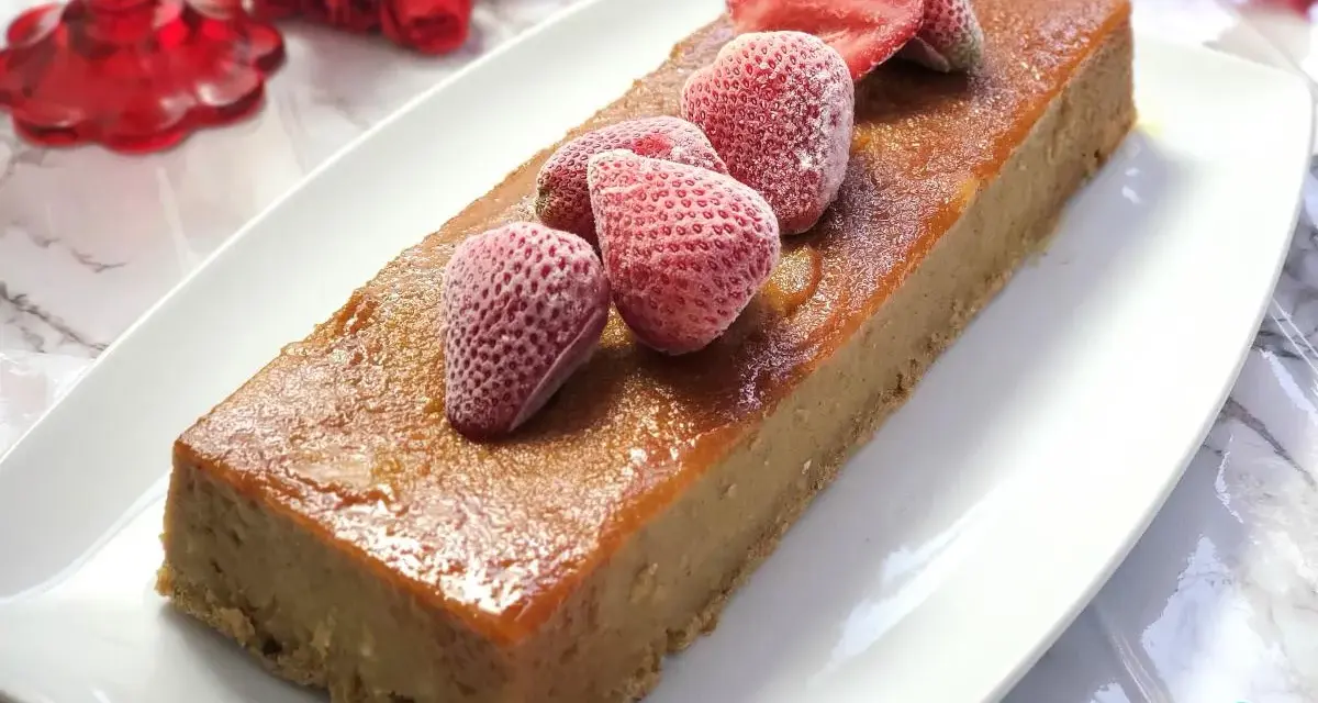 Delicioso pudin de pan casero, cubierto con fresas congeladas y un glaseado dorado.