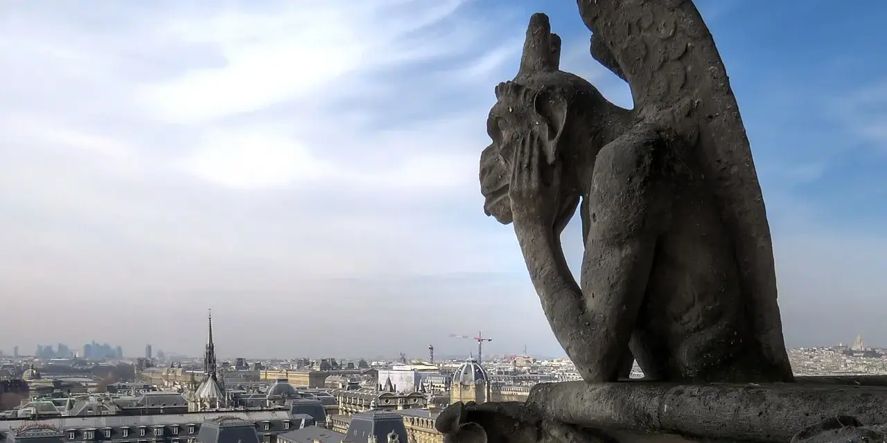Stryge de Notre Dame, pensif, contemple Paris sous un ciel bleu et nuageux.