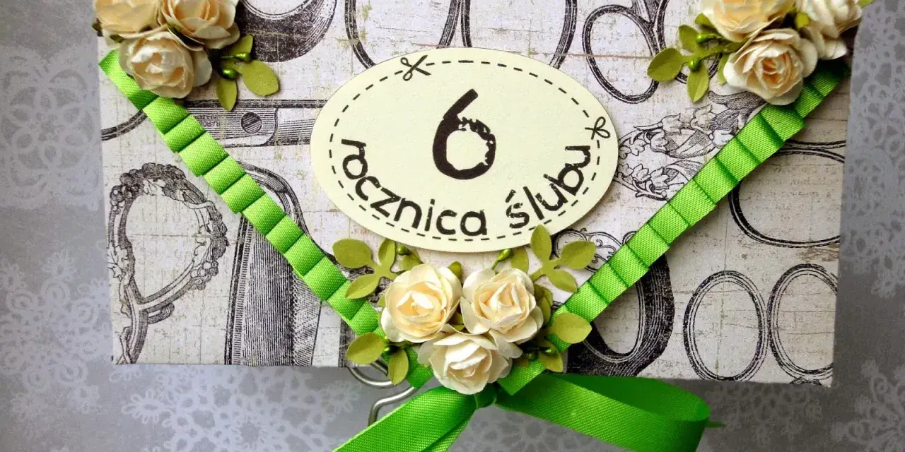 Elegancka kartka z ozdobami kwiatowymi i zieloną wstążką, z napisem "6 rocznica ślubu".