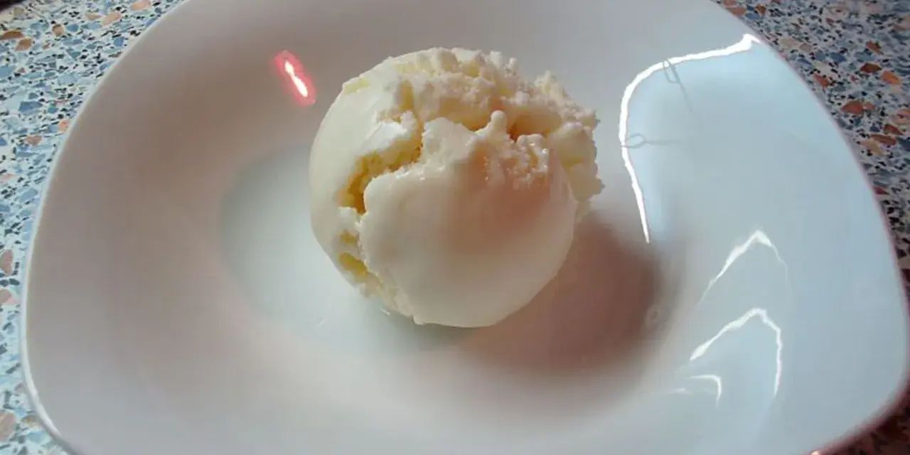 Eine Kugel cremiges Quark Eis in einer weißen Schale, bereit zum Genießen.