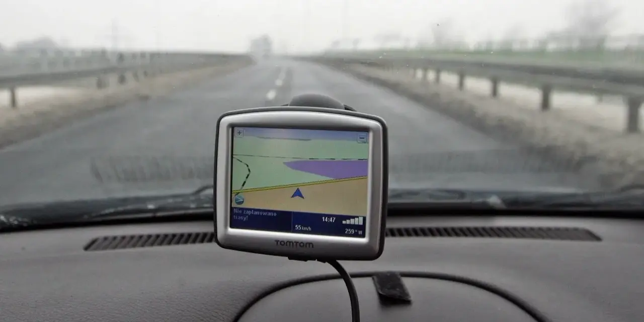 Nawigacja TomTom na desce rozdzielczej samochodu podczas jazdy w mglisty dzień.