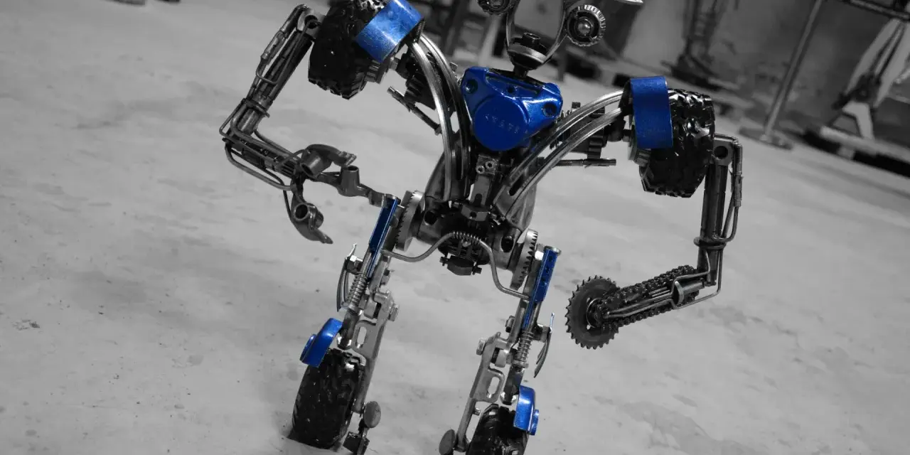 Metalowy robot z niebieskimi akcentami, wyglądający jakby właśnie opuścił fabrykę robotów w Mosznej.