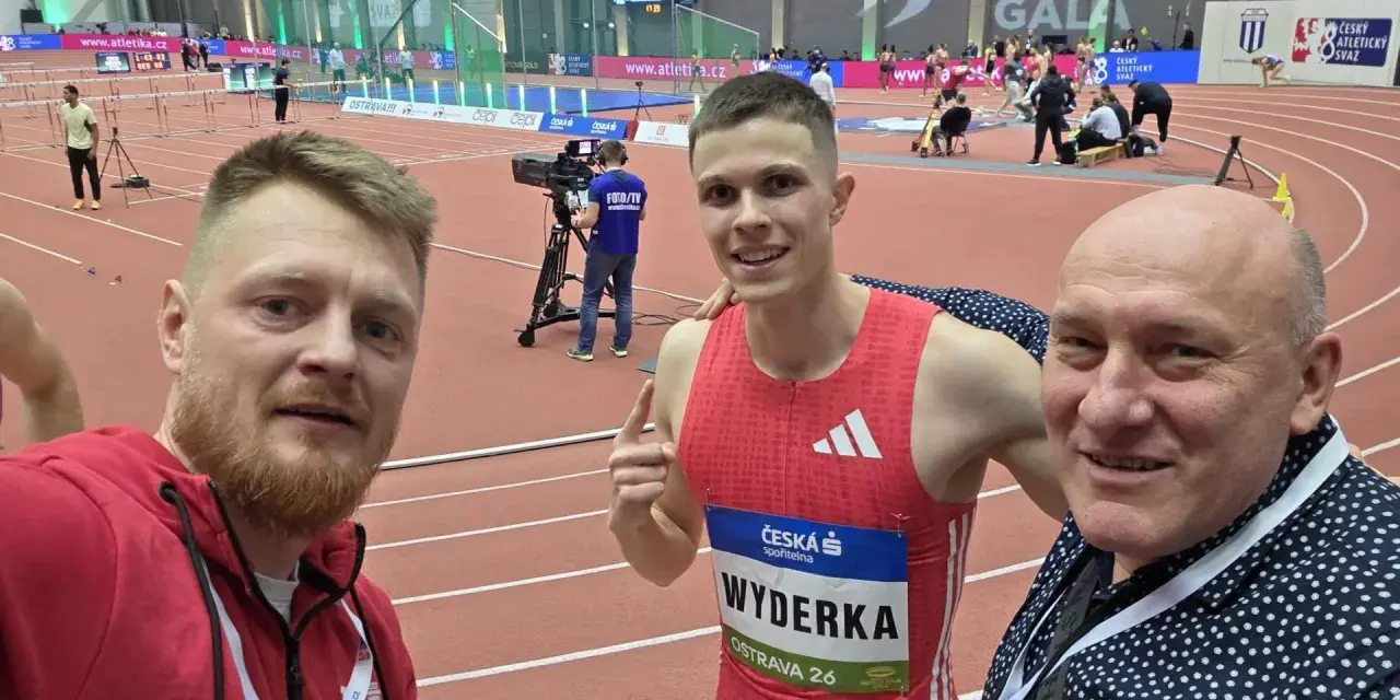 Trzej mężczyźni na bieżni lekkoatletycznej. W środku zawodnik Maciej Wyderka w stroju sportowym.