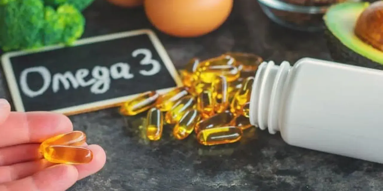 Kapsułki omega 3 na co? Na zdrowie! W tle brokuły, jajka, awokado i siemię lniane.