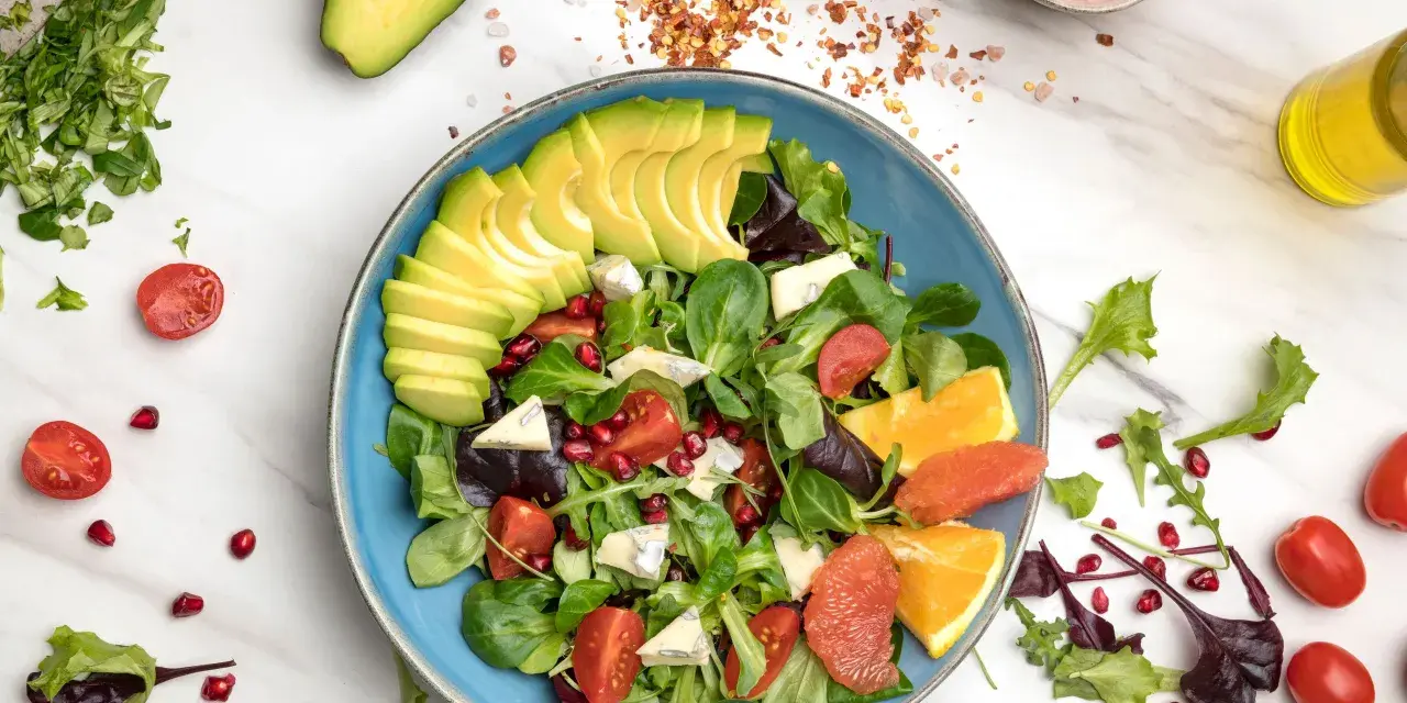 Insalata di avocado fresca con pomodorini, melograno, agrumi e formaggio blu.