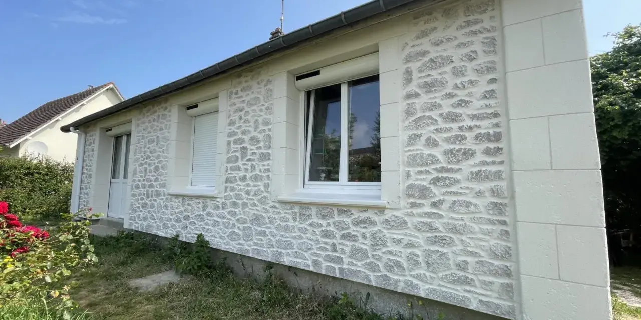 Façade de maison rénovée avec un enduit à la chaux imitant la pierre. Belle utilisation de la chaux pour un aspect authentique.