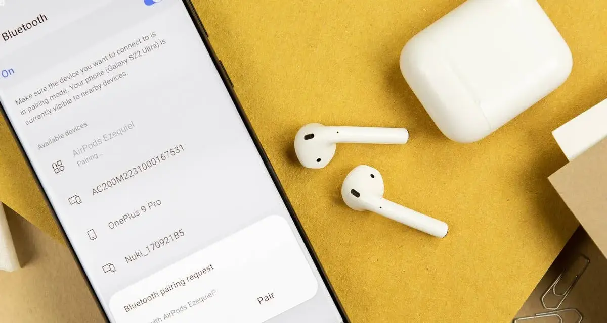 Samsung-Smartphone zeigt Bluetooth-Kopplungsanfrage für AirPods an, daneben liegen AirPods und Ladecase.