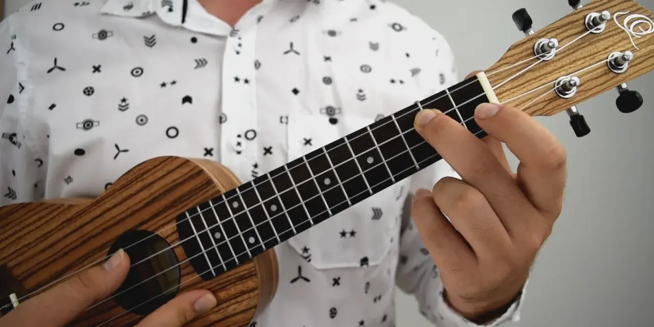 Dłoń dociska struny ukulele, tworząc akord. To jak czytanie tabulatury na gitarze, tylko na mniejszym instrumencie.