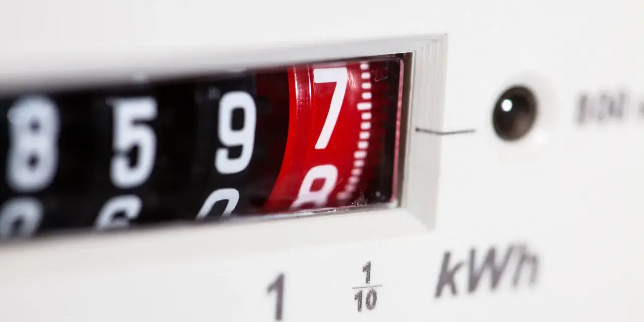 Zbliżenie na licznik przedpłatowy pokazujący 8597 kWh. Cyfry na obrotowych bębenkach, jeden z nich czerwony.