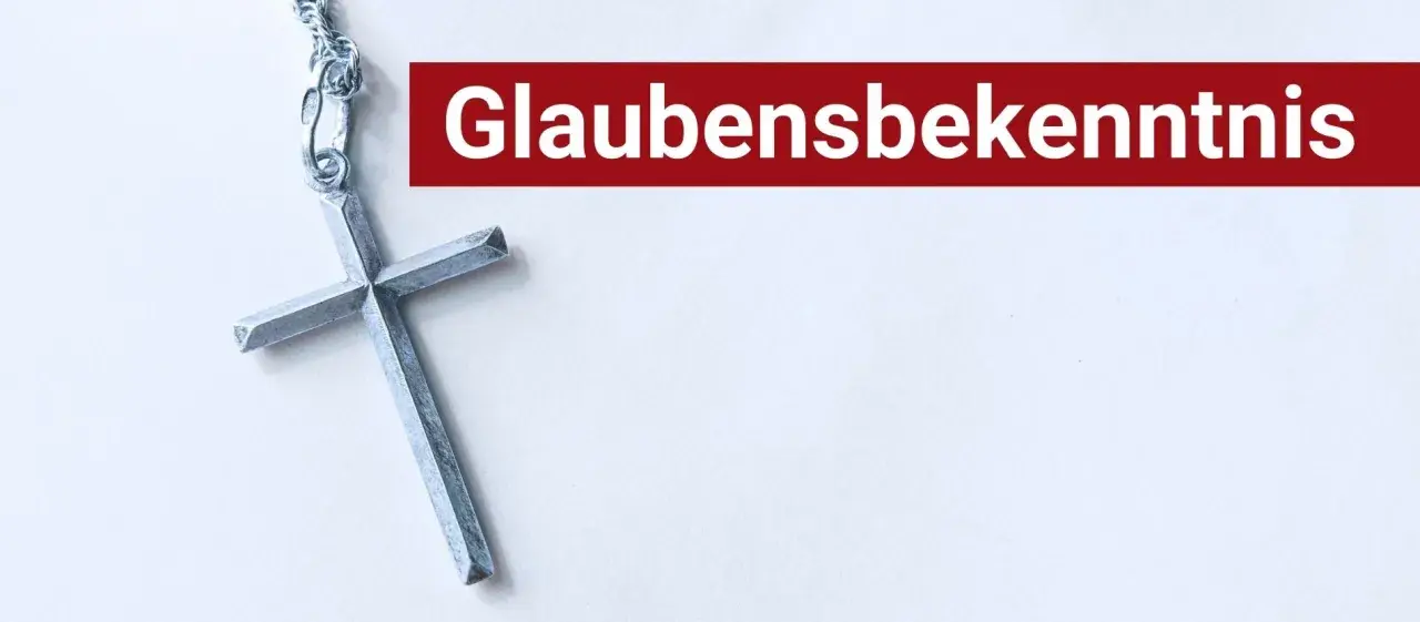 Ein silbernes Kreuz liegt neben dem Schriftzug "Glaubensbekenntnis".
