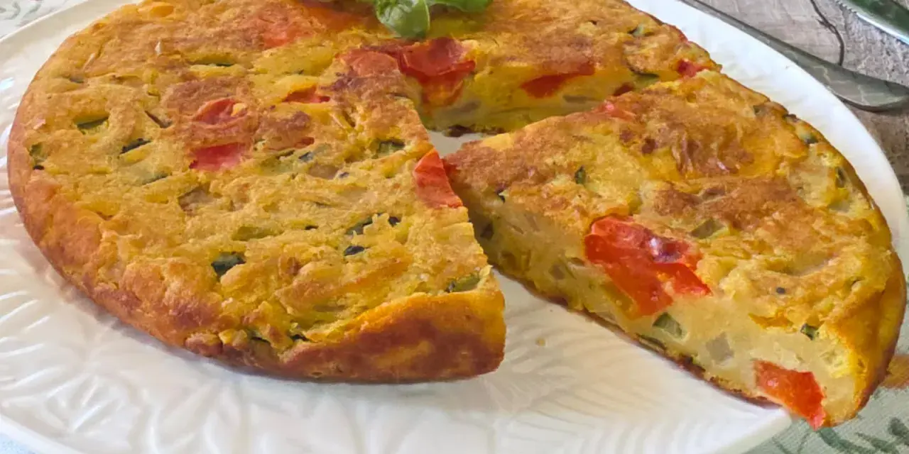 Herzhafte Frittata mit Gemüse, zubereitet in der frittata pfanne oder ofen, garniert mit Basilikum.