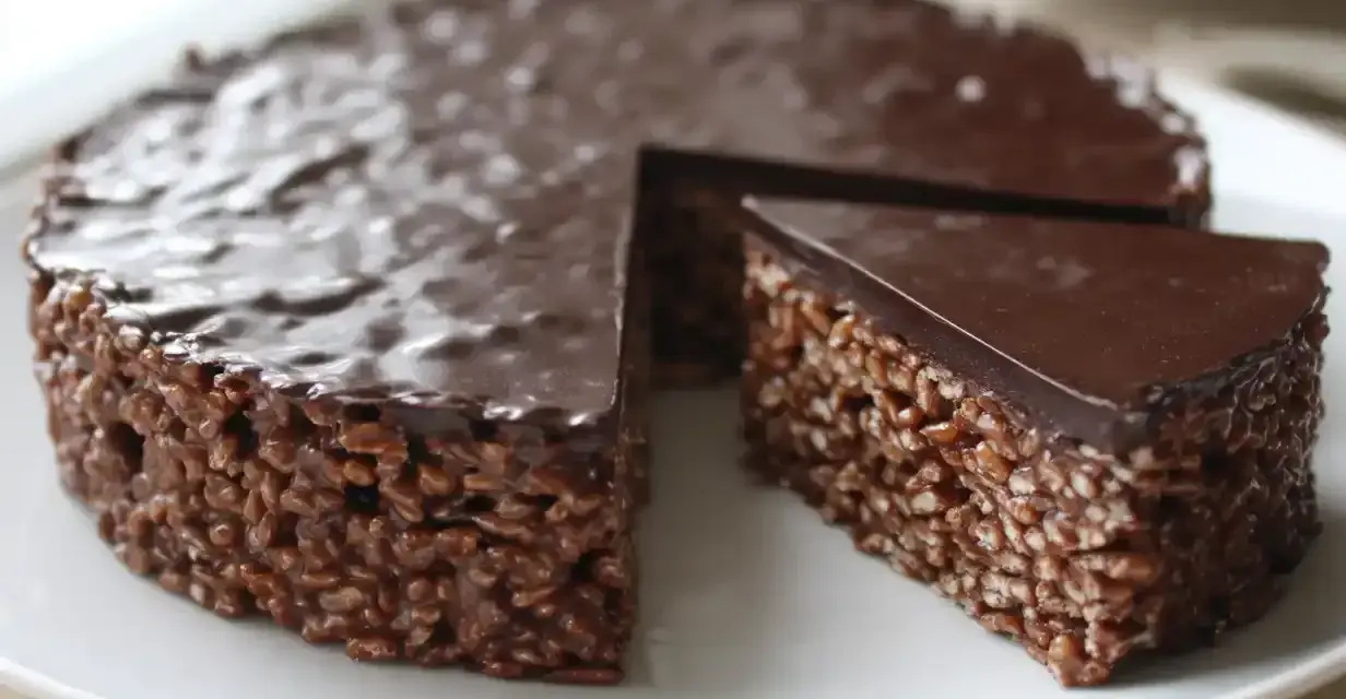 En chokladig rice crisp tårta med en bit borttagen, redo att avnjutas.