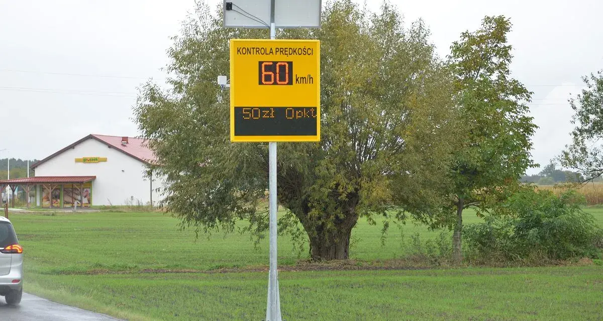 Tablica informuje o kontroli prędkości: 60 km/h, mandat 50 zł. To przypomnienie o taryfikatorze mandatów.