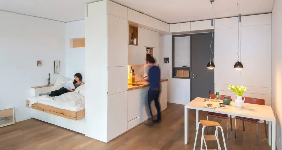Un letto sospeso, una cucina moderna e un tavolo da pranzo creano un ambiente accogliente in queste case piccole bellissime.