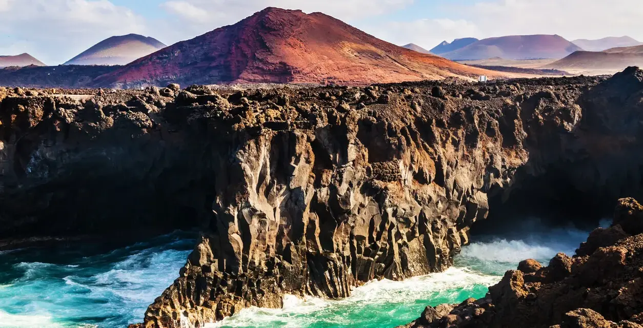 Wulkaniczne klify na Lanzarote, turkusowe morze i malownicze góry. Idealna pogoda na odkrywanie wyspy.