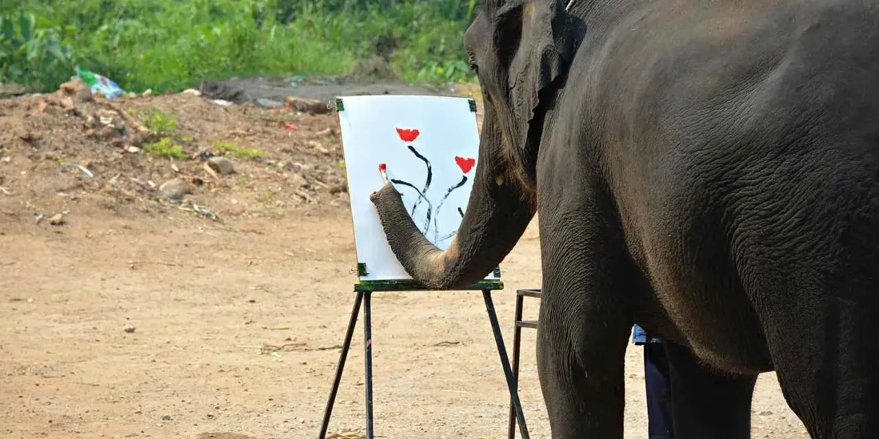 En elefant målar blommor på en duk med sin snabel.