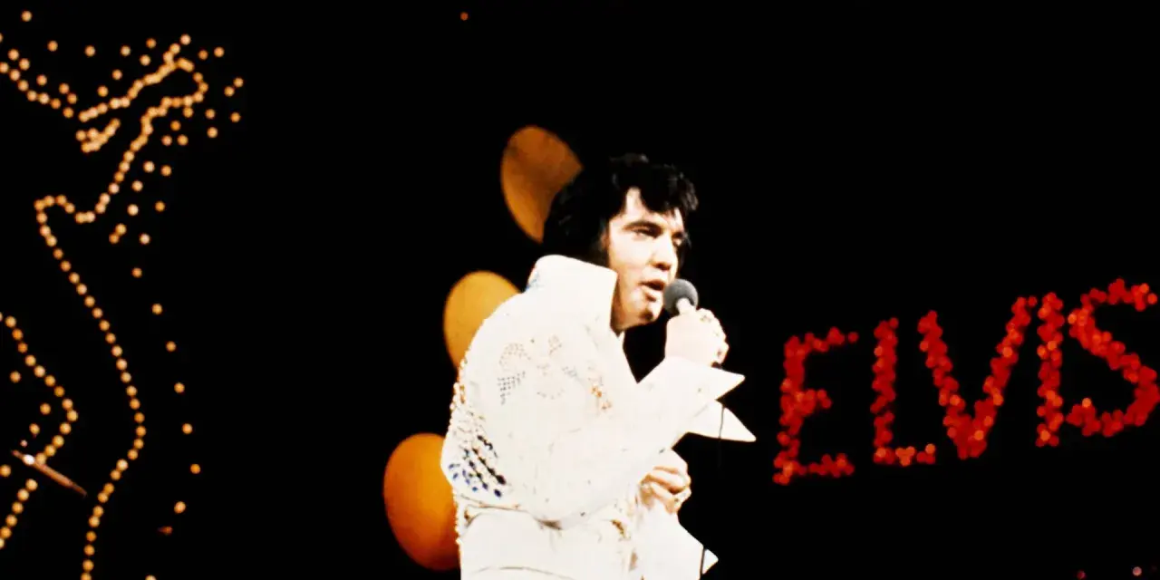 Elvis Presley singt in Hawaii, sein Name leuchtet in roten Lichtern.
