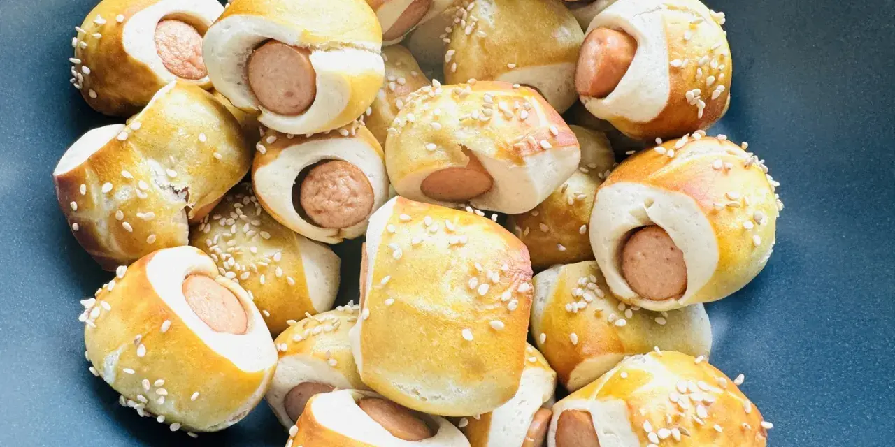 Leckere Würstchen im Teigmantel, bestreut mit Sesam. Perfekt als Fingerfood für eine Babyparty, diese Rezepte sind ein Hit!