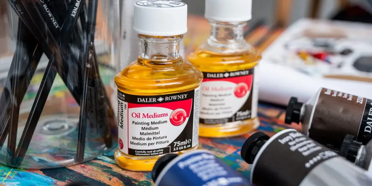 Pinceaux, flacons d'huile médium Daler Rowney et tubes de peinture à l'huile. La question "peut on mettre du gesso sur peinture à l'huile" plane sur cet atelier.