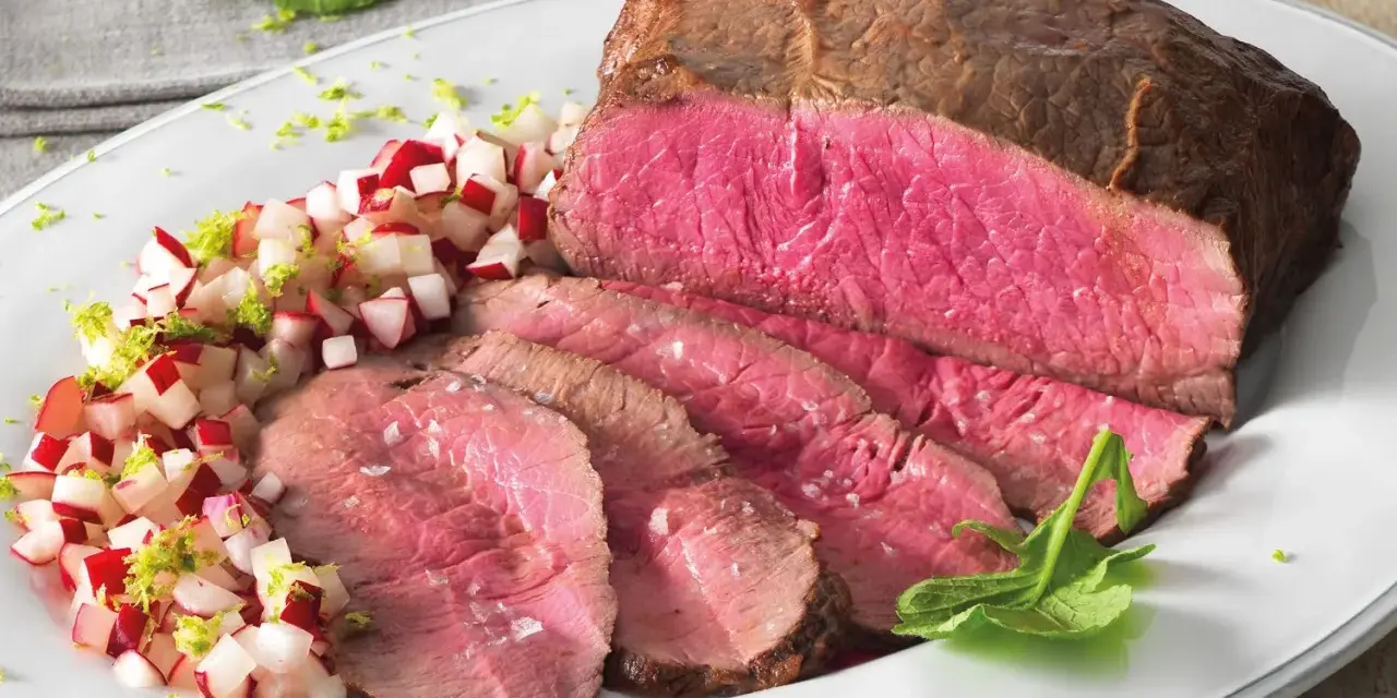 Roast beef ricetta in pentola: succulento arrosto affettato con contorno di ravanelli e scorza di lime.