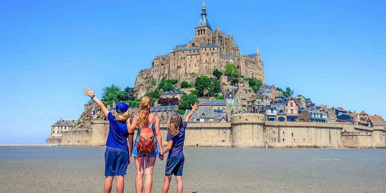 Famille en visite à Mont Saint-Michel, émerveillée par le château perché sur son îlot rocheux.