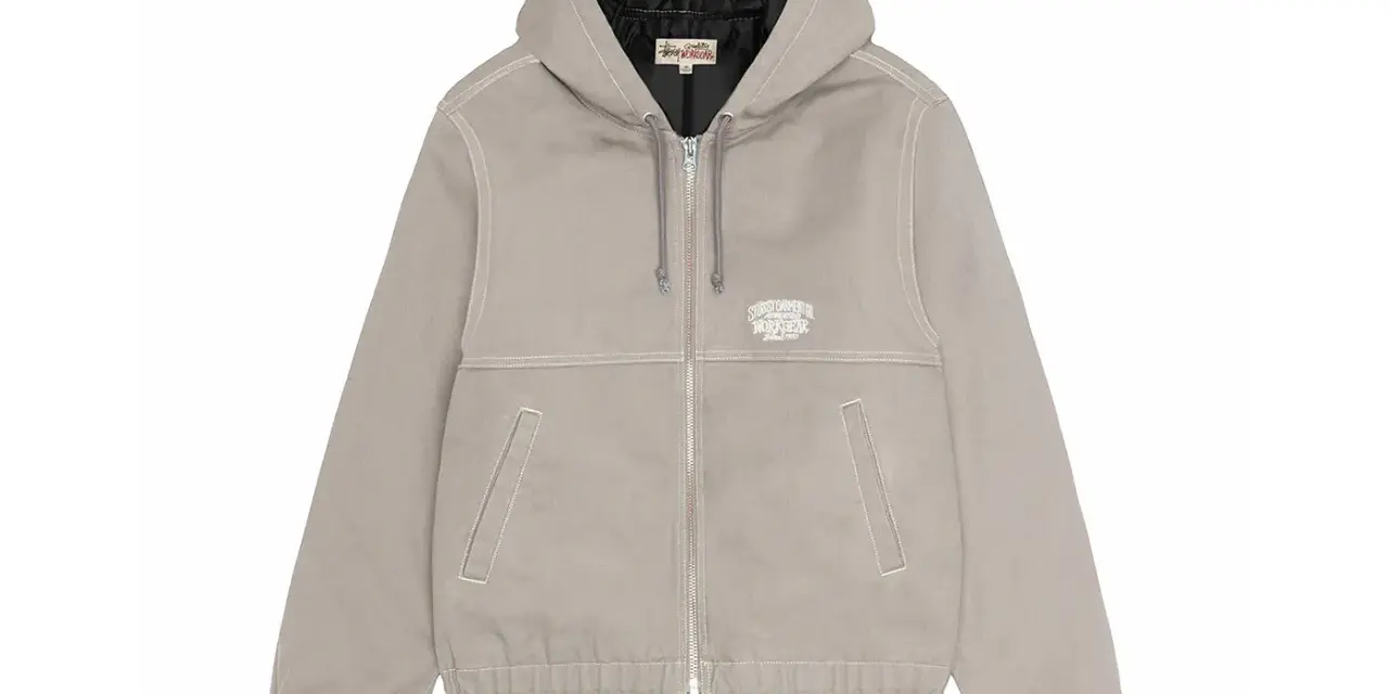 Giacca Stussy work jacket grigia con cappuccio, zip frontale e logo ricamato sul petto. Perfetta per un look casual e resistente.