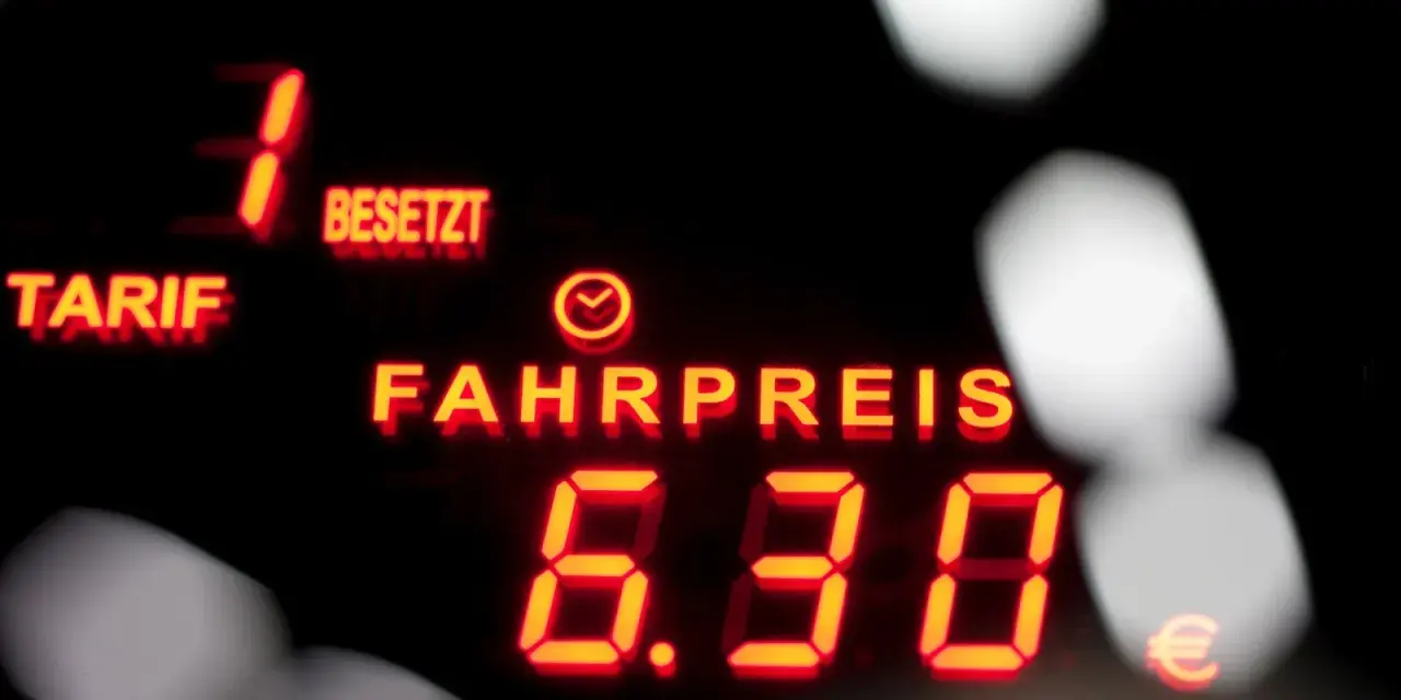 Rotes Leuchtdisplay zeigt "FAHRPREIS 6.30 €". Der taxameter preis ist klar ersichtlich.