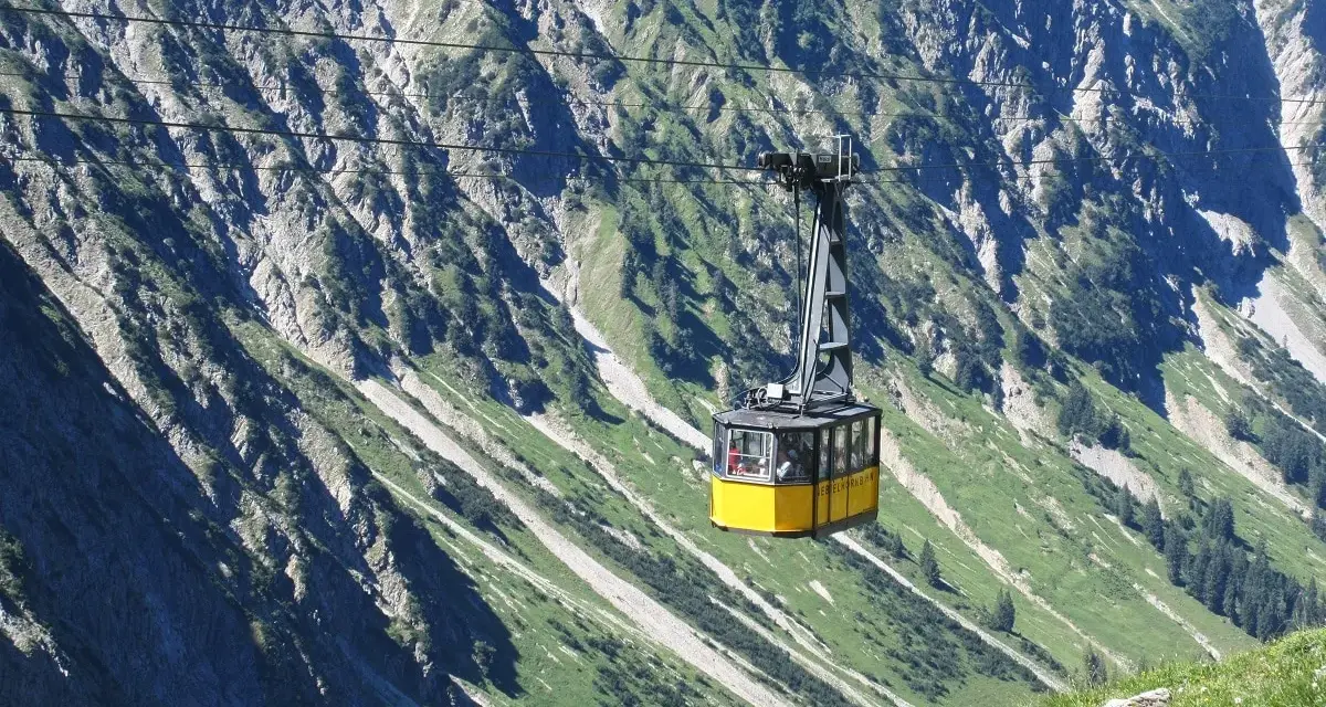 Gelbe Seilbahn schwebt über steile Hänge, ideal für eine Nebelhorn Wanderung.