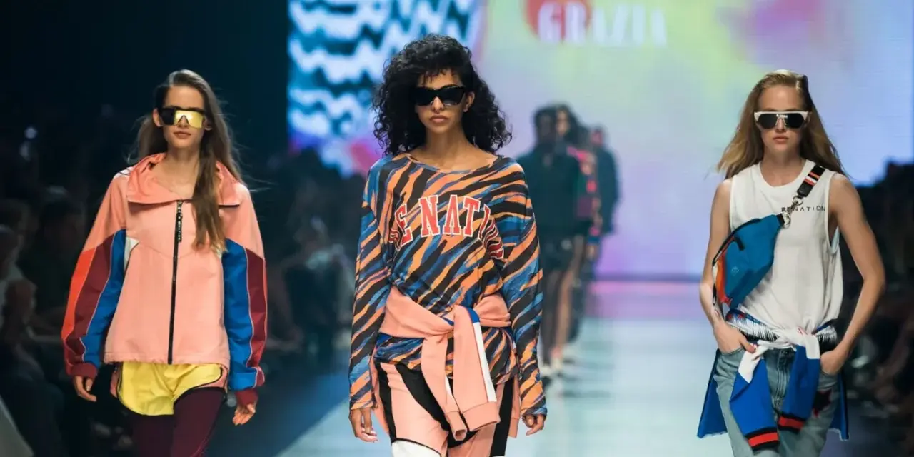Modelki na wybiegu prezentują stylizacje, które idealnie sprawdzą się, jak się ubrać na imprezę w stylu lat 90. Kolorowe bluzy, dresy i neonowe dodatki.