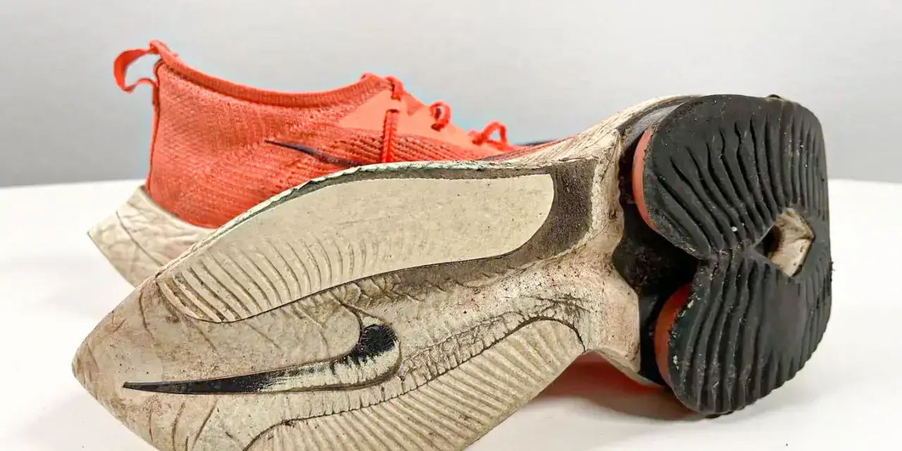 Scarpe da camminata usurate, con suola consumata e tomaia arancione. È ora di cambiarle per continuare a correre in sicurezza.