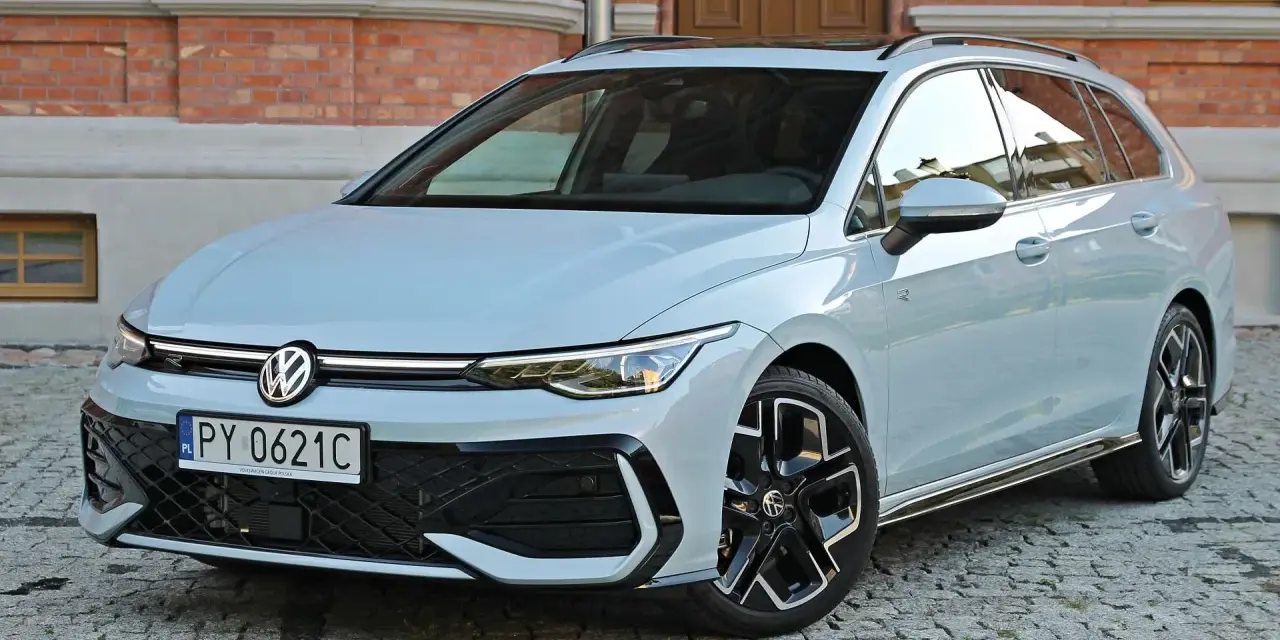Jasny VW Golf 8 Variant na brukowanej ulicy przed ceglanym budynkiem. Elegancki kombi z nowoczesnym designem.