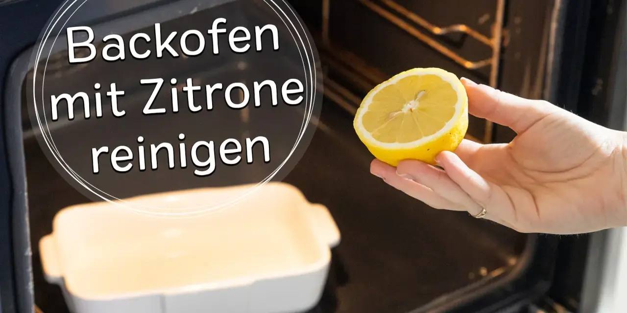 Backofen reinigen mit Zitrone: Eine Hand hält eine halbe Zitrone über eine leere Auflaufform im dunklen Backofen.
