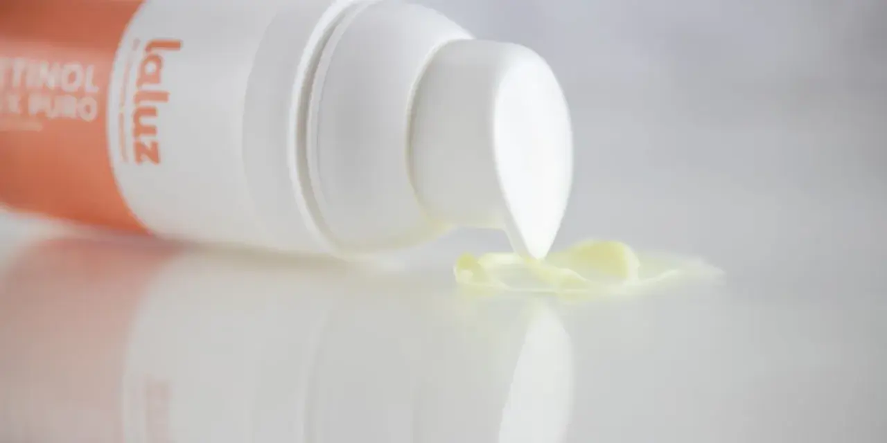 Crema con retinoides que son, de la marca La Luz, con una gota de producto cayendo del dispensador.