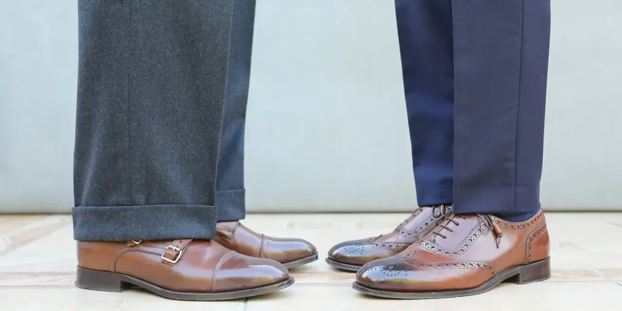 Długość spodni garniturowych: jeden model ma wywinięte nogawki, drugi gładkie. Eleganckie buty męskie.